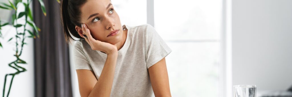 European thinking woman working with papers while having breakfast