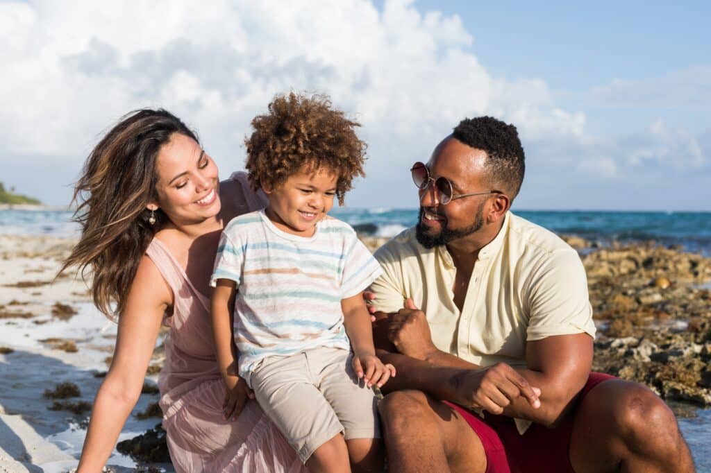 Laughing family sitting on beach