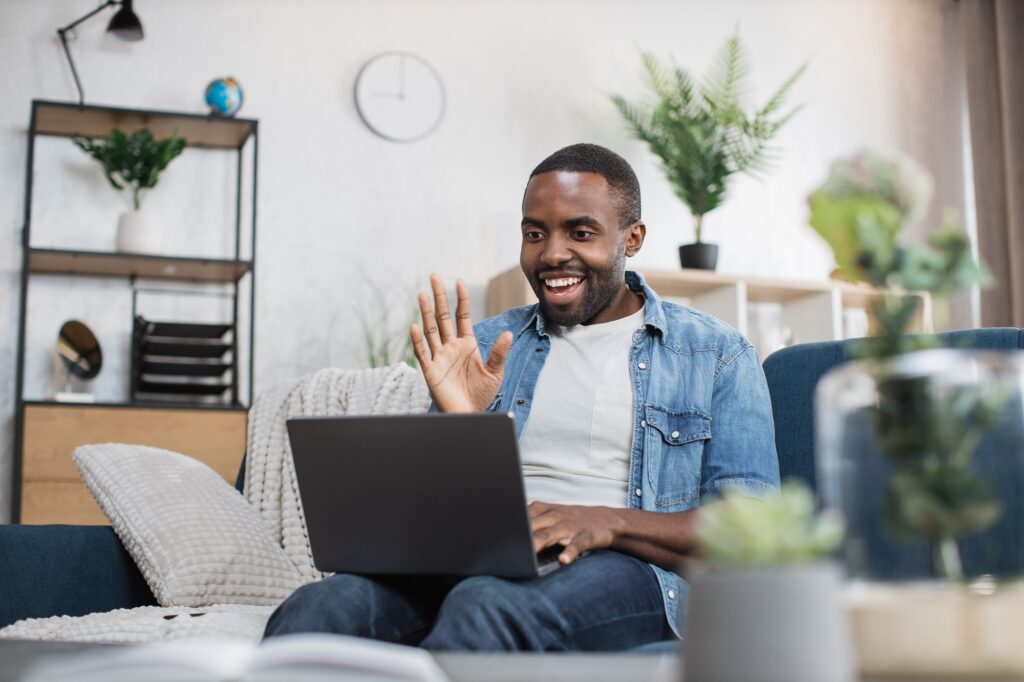 Happy african american guy having video call on laptop