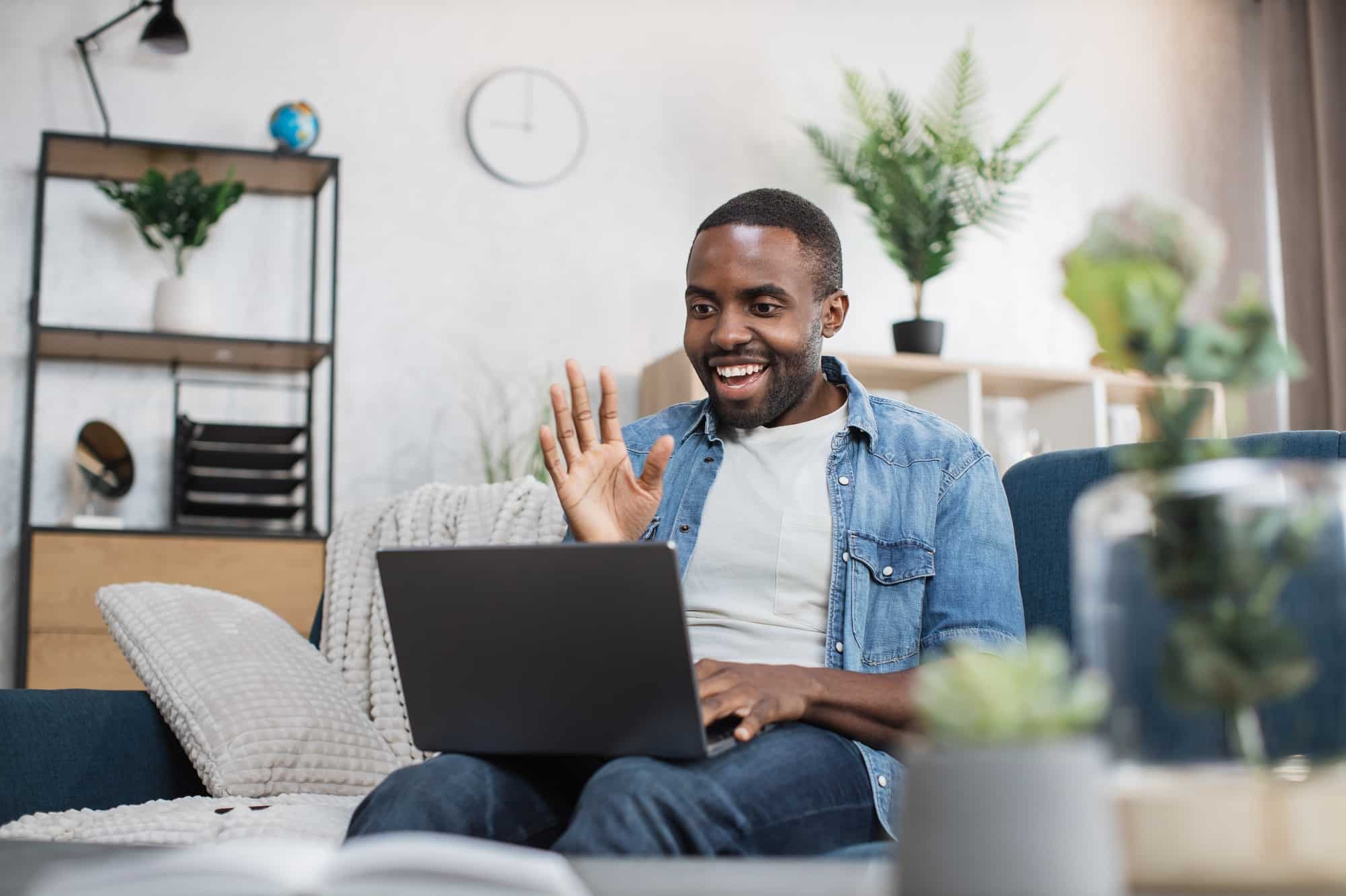 Happy african american guy having video call on laptop